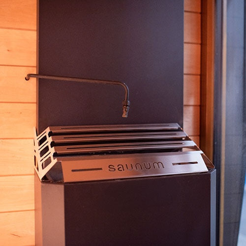 Saunum AutoLeil spray nozzle above a Saunum heater (heater and pre-bent pipe sold separately)
